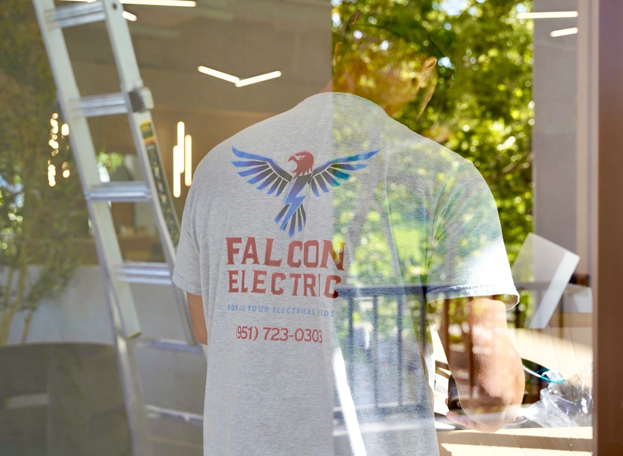 Ean Orchard reflected in glass, Falcon Electric shirt visible